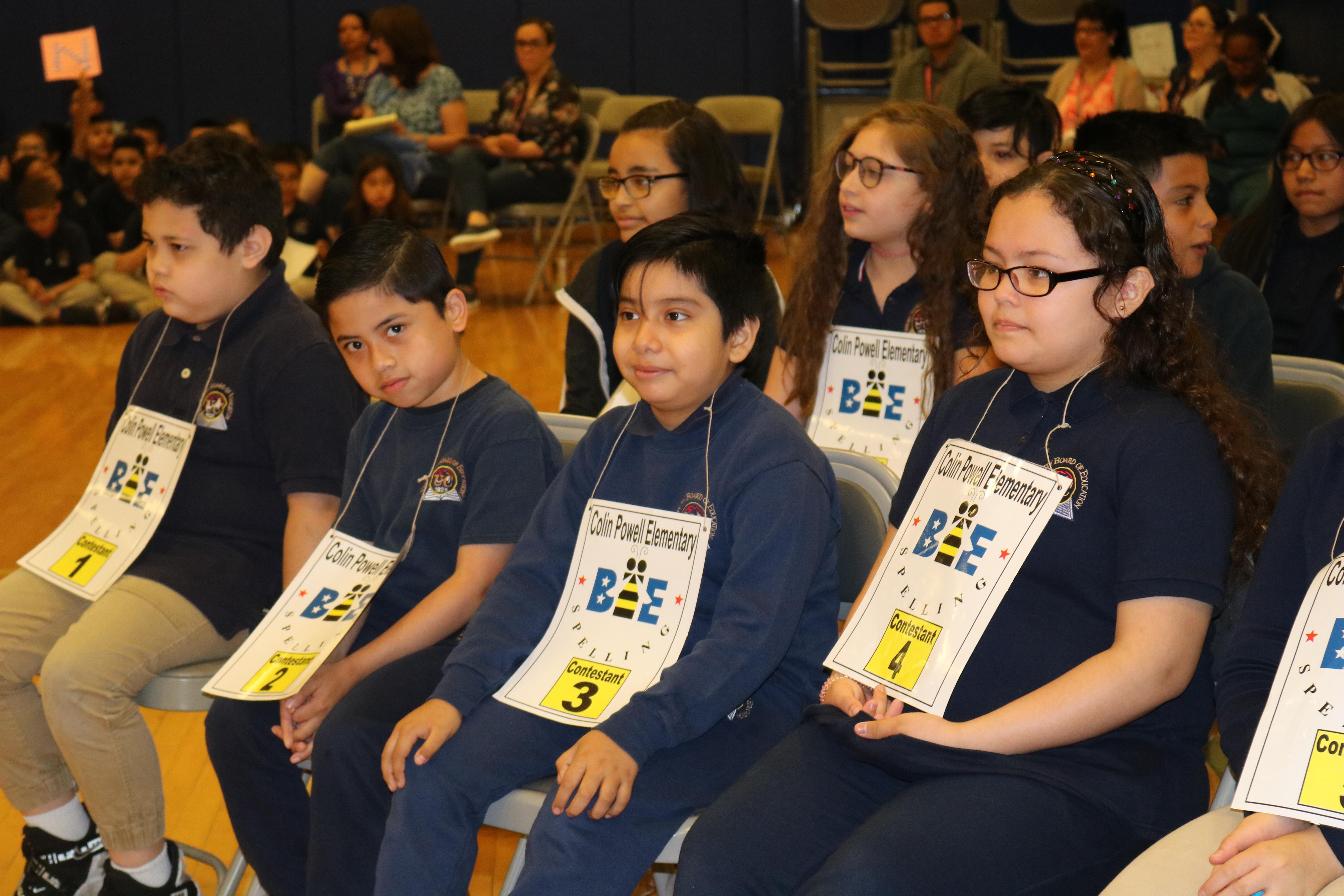 spelling bee contestants seated in chairs