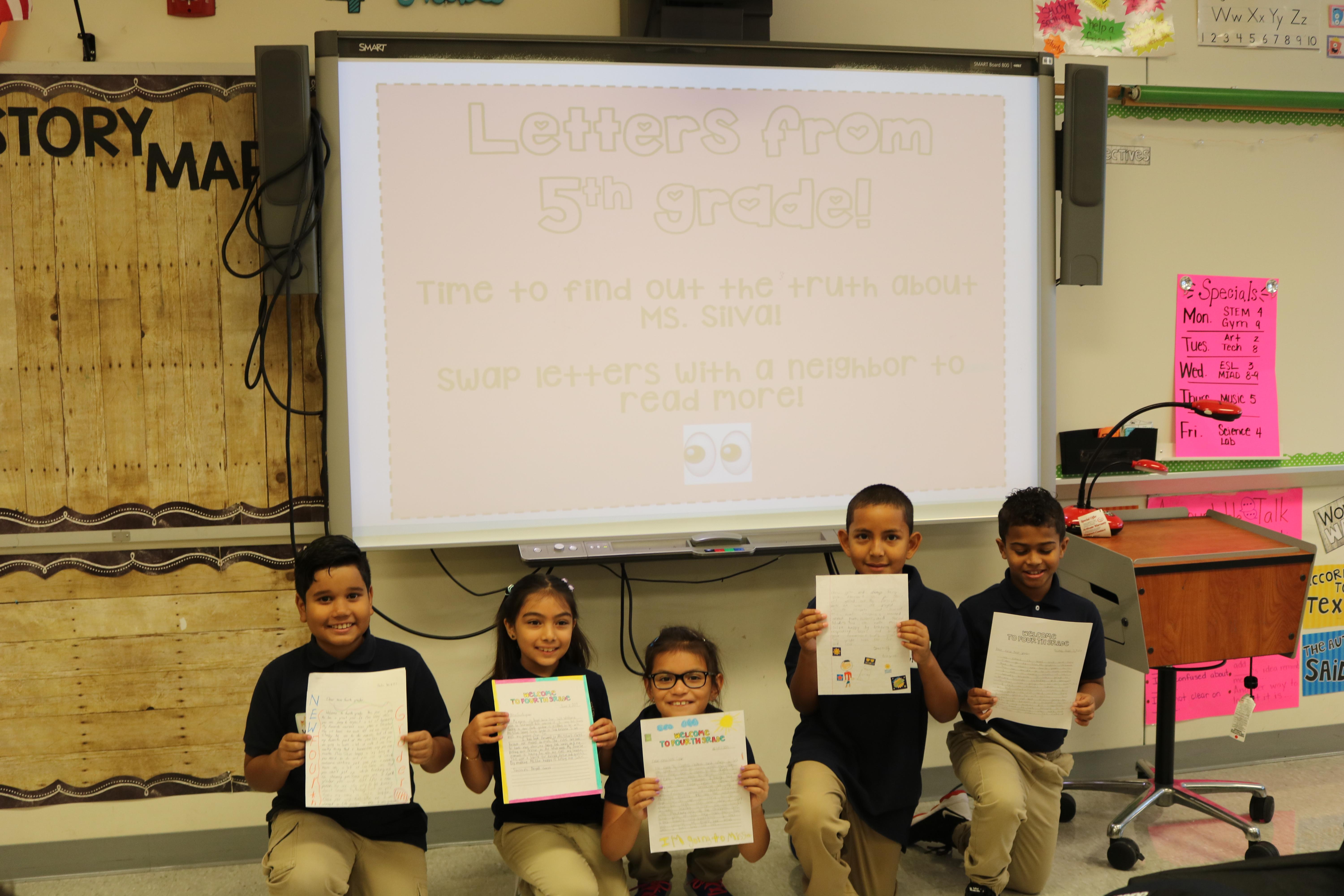 5th grade students proudly showing off their first assignments