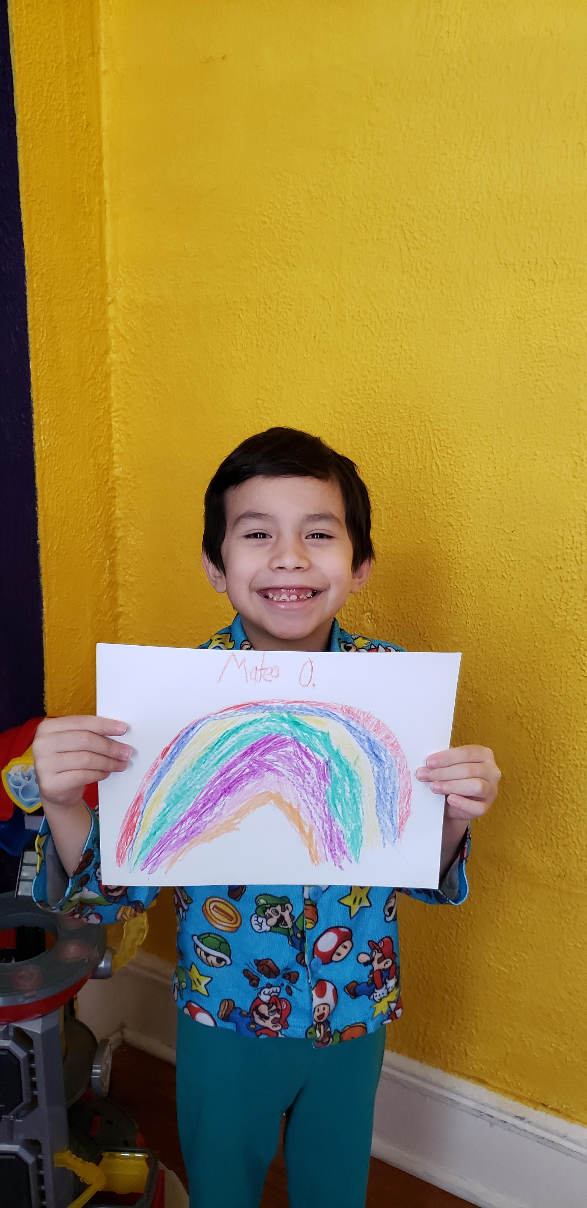 boy showing off his rainbow drawing